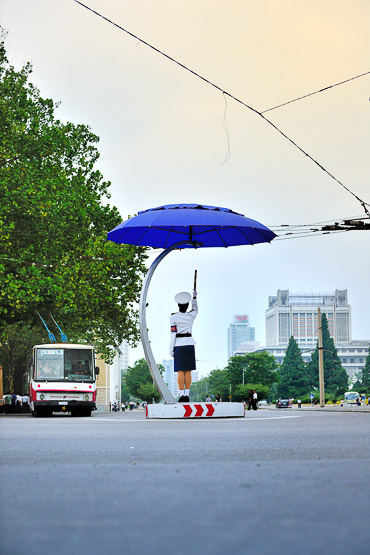 Dolled up in blue and white uniforms, pretty girls work the middle of intersections.