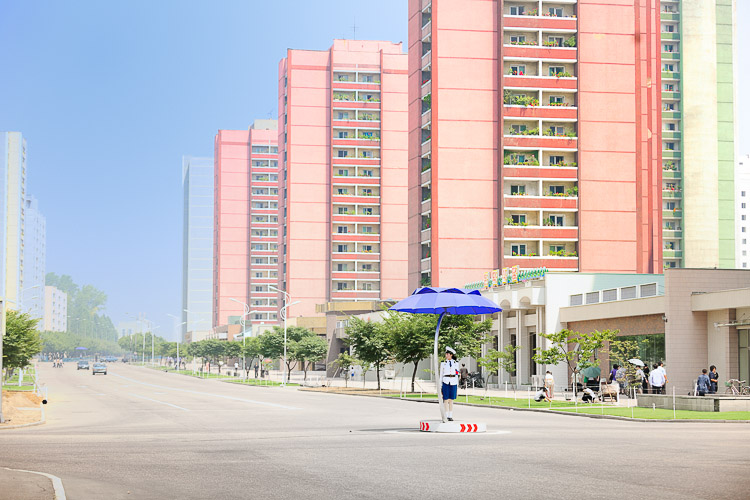 Dolled up in blue and white uniforms, pretty girls work the middle of intersections.